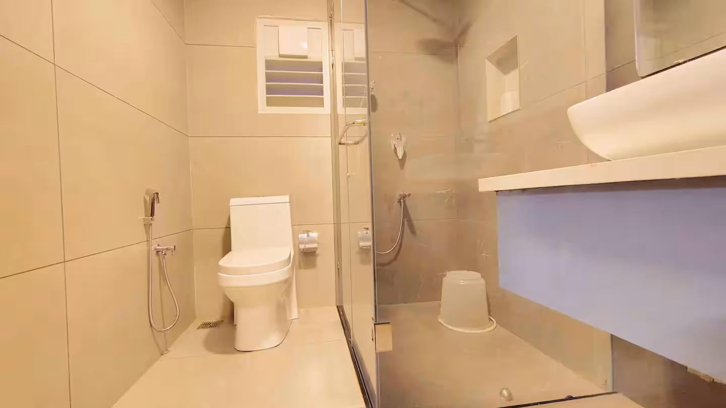 Spacious attached bathroom with clean vanity and complimentary amenities